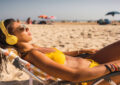 https://media.gettyimages.com/id/1351875042/photo/girl-lying-on-the-beach-sunbathing-while-listening-to-music-with-wireless-headphones.jpg?s=612x612&w=0&k=20&c=LBOrpZwlyEf7H_DSK0DLWR-ug8Q3wVsbIJG7oBBtkAU=