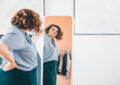 https://media.gettyimages.com/id/1369562988/photo/overweight-young-woman-in-glasses-admires-choice-of-clothes-standing-in-front-of-large-mirror.jpg?s=612x612&w=0&k=20&c=70-pyt87U8fWqhiiz0VH40q1Y5k1GtQfiA46PaNaY0A=