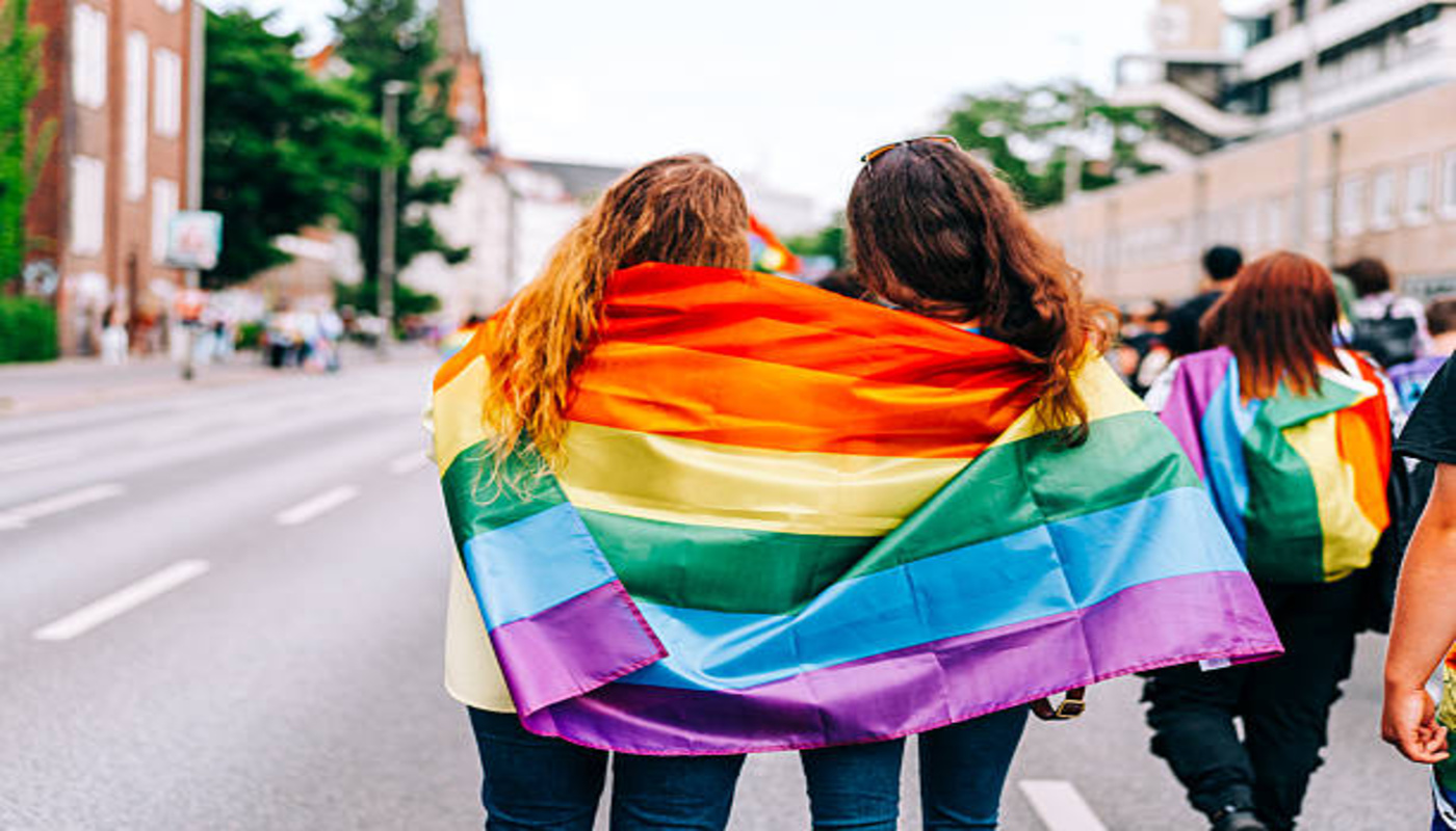 https://media.gettyimages.com/id/2274443493/photo/two-young-women-wrapped-in-a-rainbow-pride-flag-walking-on-a-city-street.jpg?s=612x612&w=0&k=20&c=GXYn7SzyrD0g6PDBaZucJKB6SgJEHbhSmPbs_2802jA=